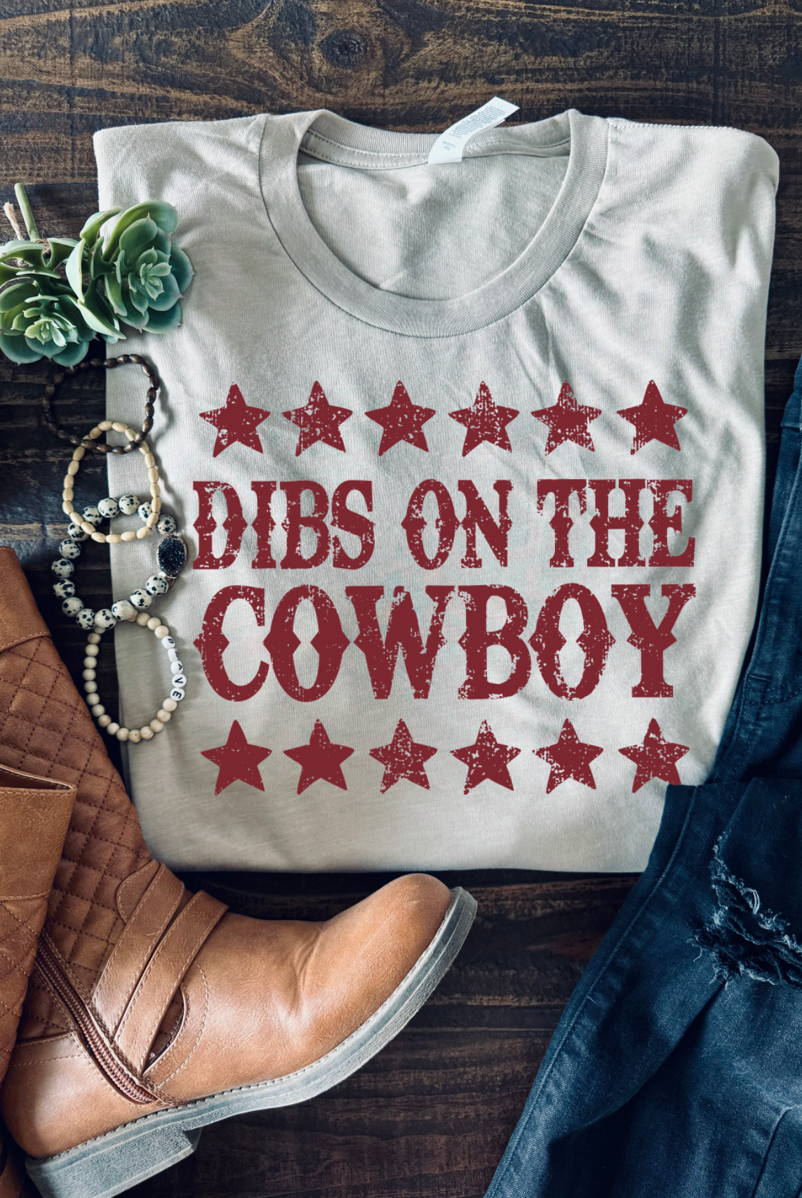 Vintage western country girl graphic tee with Dibs on the Cowboy on it. Bella and Canvas tan unisex tshirt.