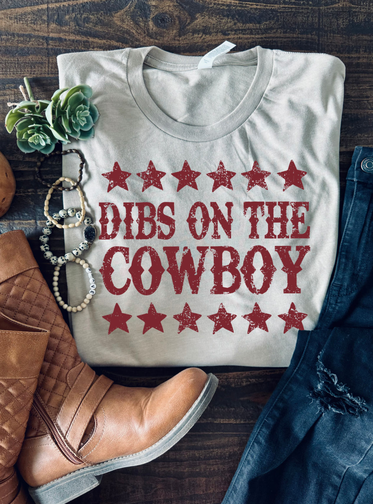 Vintage western country girl graphic tee with Dibs on the Cowboy on it. Bella and Canvas tan unisex tshirt.