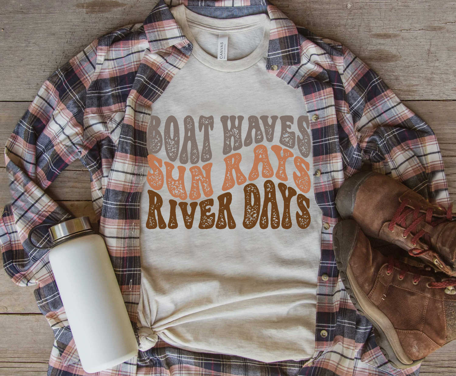 Vintage distressed boat waves, sun rays, river days tee that is a Bella and Canvas brand in cream.