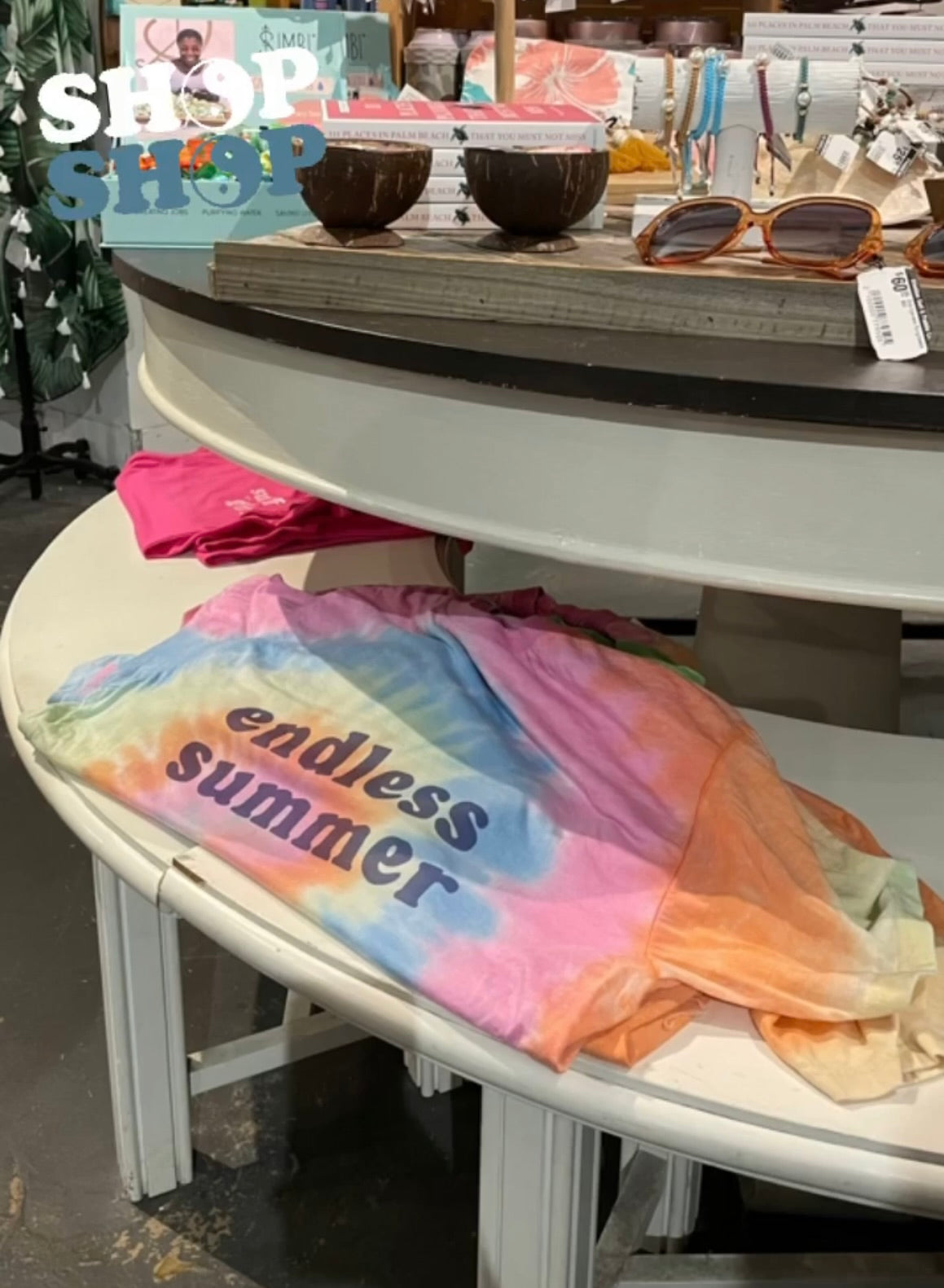 Vintage tie-dyed shirt featuring an endless summer graphic on it displayed in a surf shop.