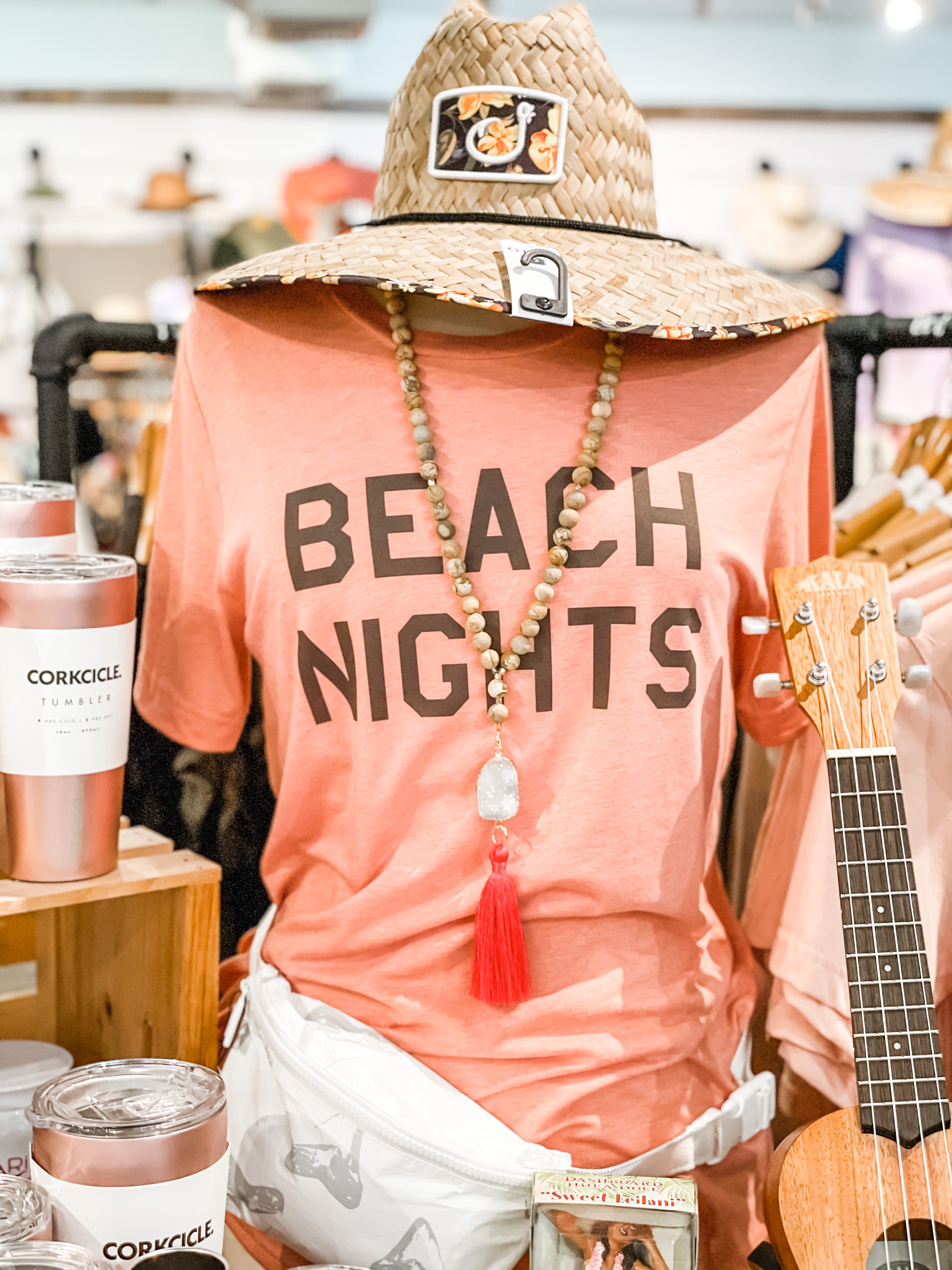 T-shirt showcases in Blueline Surf and Paddle shop with the text "Beach Nights," featuring a design that captures the essence of relaxing and enjoying evenings at the beach.