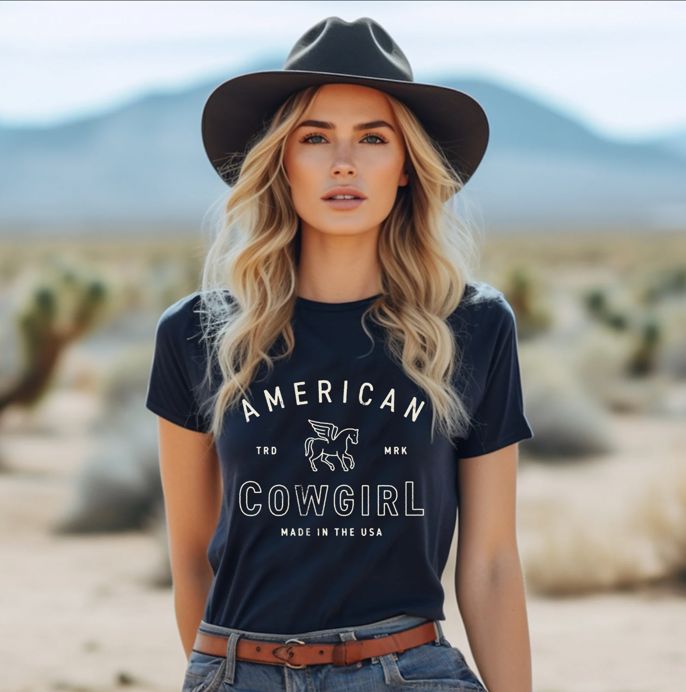 Black t-shirt with the text "American Cowgirl" in a western-style design, perfect for showcasing country pride and rodeo style.