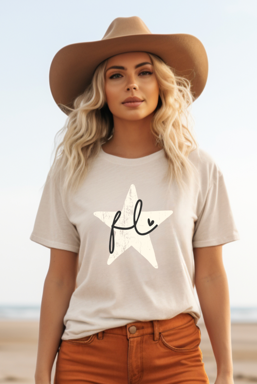 Cream colored soft shirt from Bella and Canvas, this shirt has a rustic star with Florida written in cursive with an adorable heart.