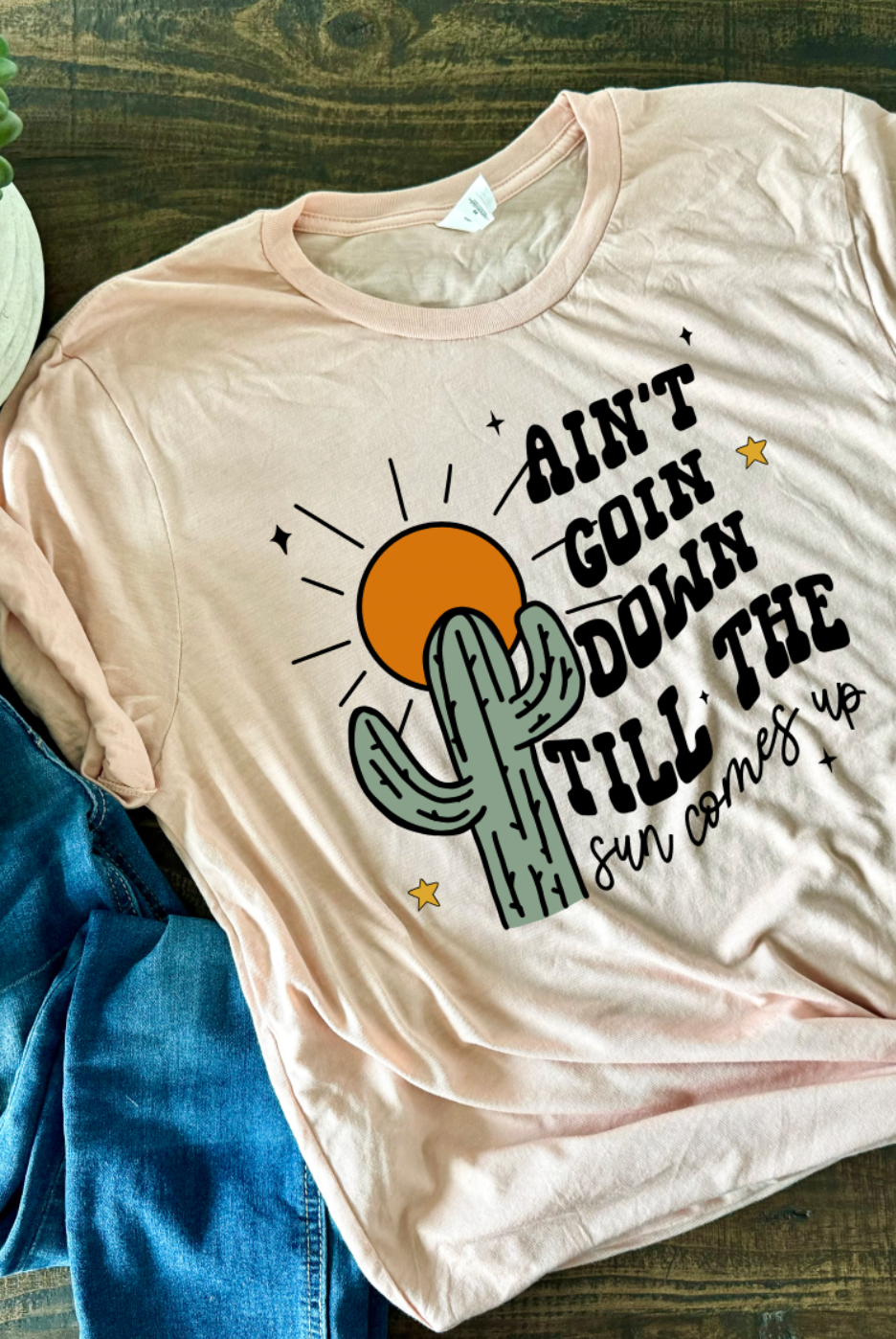 Peach Colored Bella and Canvas Unisex Tshirt with Ain't Goin Down Till The Sun Comes Up on it. Handmade in TX.
