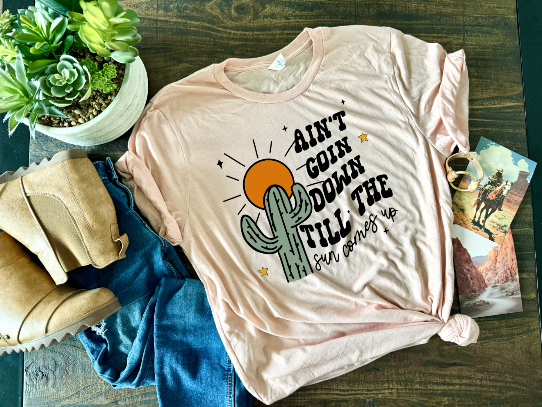 Peach Colored Bella and Canvas Unisex Tshirt with Ain't Goin Down Till The Sun Comes Up on it. Handmade in TX.