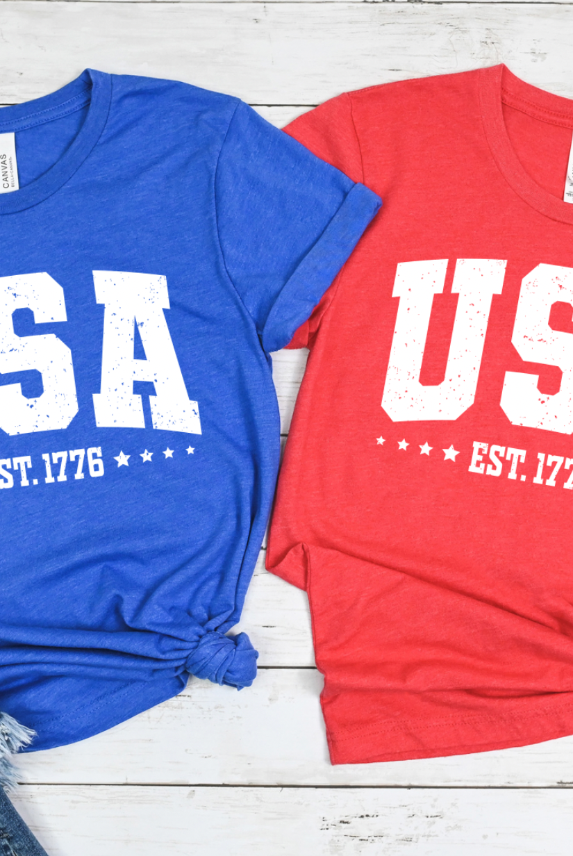 USA Est. 1776 with stars on a classic heathered red and blue Bella and Canvas tshirt. Americana 4th of July graphic tee.